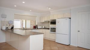 a kitchen with white appliances and a white refrigerator at Elandra At Old Bar in Old Bar