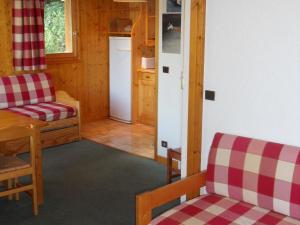 ein Wohnzimmer mit einem Tisch und Stühlen sowie eine Küche in der Unterkunft Spacious flat in M ribel near the ski lifts in Méribel