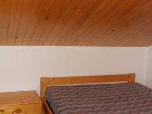 Bett in einem Zimmer mit Holzdecke in der Unterkunft Spacious flat in M ribel near the ski lifts in Méribel