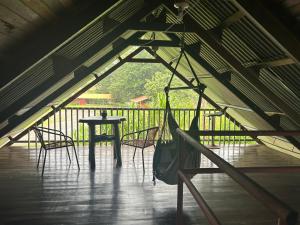 a room with a hammock and a table and chairs at Cabaña Río Sarapiquí in Sarapiquí