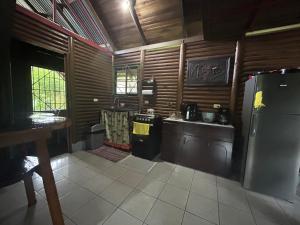 a kitchen with wooden walls and a refrigerator and counters at Cabaña Río Sarapiquí in Sarapiquí