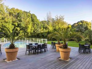 a deck with a table and chairs and trees at Mercure Agen Centre in Agen