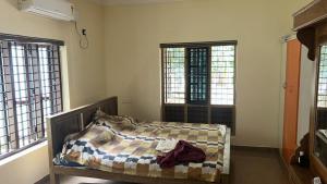 a bedroom with a bed in a room with windows at Zayas in Kundara