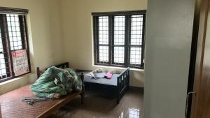 a room with a bed and a table and windows at Zayas in Kundara