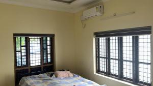 a bedroom with two windows and a bed in it at Zayas in Kundara