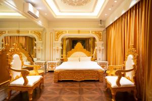 a bedroom with a king sized bed and two chairs at Melon Hotel Tố Hữu in Trung Văn