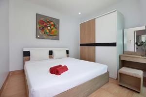 a bedroom with a white bed with a red object on it at 3 BR Pool Villa Lancelot in Rawai in Ban Saiyuan (1) +16 photos