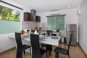 a kitchen with a table with chairs and a refrigerator at 3 BR Pool Villa Lancelot in Rawai in Ban Saiyuan (1)