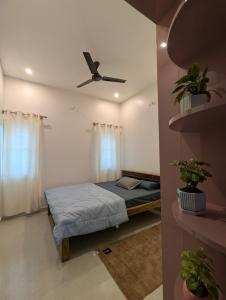 a bedroom with a bed and a ceiling fan at Elite Homes in Chikmagalūr