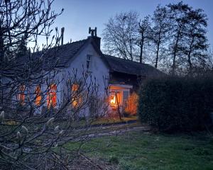 ein weißes Haus mit eingeschalteten Lichtern in der Unterkunft Slowflower in Ophemert