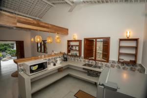 a kitchen with a sink and a microwave at Villa Paranawatta in Unawatuna