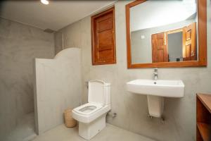 a bathroom with a toilet and a sink and a mirror at Villa Paranawatta in Unawatuna