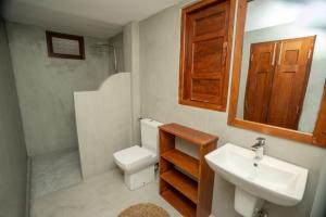 a bathroom with a sink and a toilet and a mirror at Villa Paranawatta in Unawatuna +2 photos