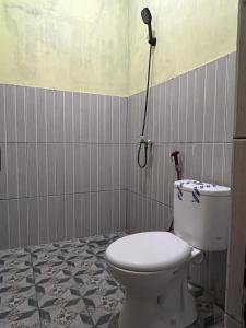 a bathroom with a toilet and a shower at Bunaken Scuba Guest House in Bunaken +18 photos