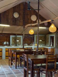 a dining room with wooden tables and chairs at The Cove Pasikuda - Eco Retreat in Pasikuda