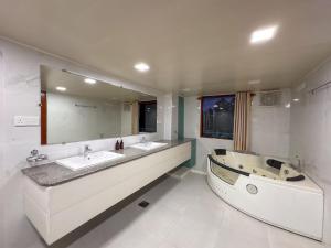 a bathroom with two sinks and a tub and a large mirror at Moi Ella by DBI in Ella