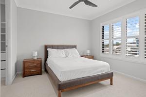 a white bedroom with a bed and a ceiling fan at Spacious 4 Bed Home with Pool & Garden in Griffin