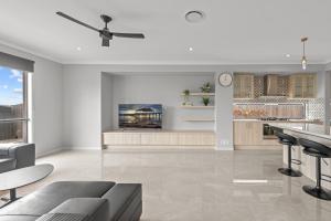 a white living room with a ceiling fan at Spacious 4 Bed Home with Pool & Garden in Griffin +14 photos
