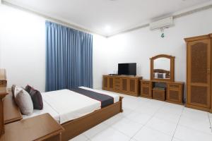 a bedroom with a bed and a tv and a mirror at Bimo Inn Malioboro in Yogyakarta