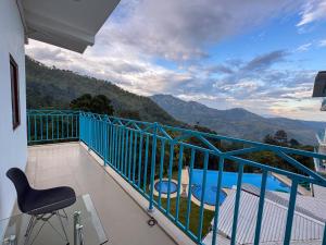 a balcony with a chair and a view of the mountains at Moi Ella by DBI in Ella