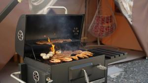 a grill with hamburgers and other food on it at Gapyeong ILUGlamping in Gapyeong