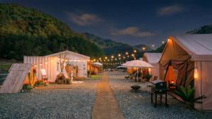 a group of tents with lights on a street at night at Gapyeong ILUGlamping in Gapyeong