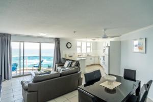 a living room with a couch and a table at Grosvenor Beachfront Apartments Surfers Paradise in Gold Coast