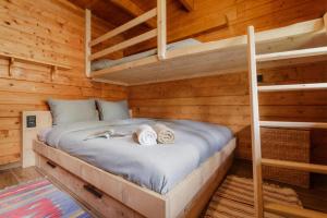 a bedroom with a bed in a log cabin at Chalet Soleada with Fireplace and Terrace for 5 - Happy Rentals in Pian San Giacomo
