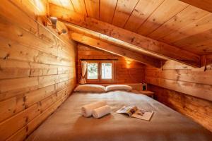 a room with a bed in a log cabin at Chalet Soleada with Fireplace and Terrace for 5 - Happy Rentals in Pian San Giacomo +18 photos