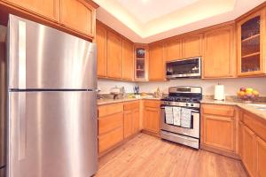 a stainless steel refrigerator in a kitchen with wooden cabinets at Healdsburg Wine Country Escape with Tasting Perks & Vineyard Views in Healdsburg