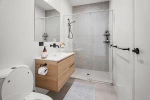 a bathroom with a shower and a toilet and a sink at Chic Flinders Park Getaway in Adelaide +13 photos