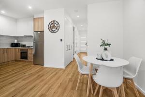 a kitchen and dining room with a table and chairs at Chic Flinders Park Getaway in Adelaide