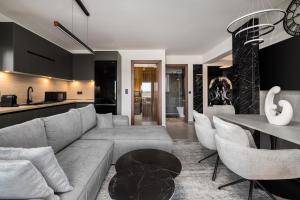 a living room with a couch and a table at Blazer suite on the sea in Neoi Epivates