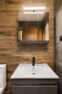 a bathroom with a white sink and a mirror at Blazer suite on the sea in Neoi Epivates +16 photos