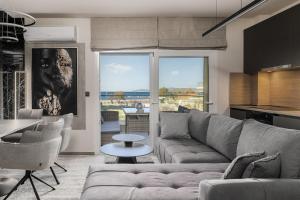 a living room with a couch and a table at Blazer suite on the sea in Neoi Epivates