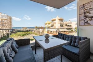 a living room with a table and chairs on a balcony at Blazer suite on the sea in Neoi Epivates