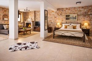 a bedroom with a bed and a stone wall at Villa Anemos in Nafplio