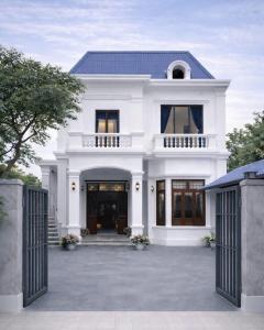 a white house with a gate in front of it at Anh Dung Homestay in Ga Thừa Lưu