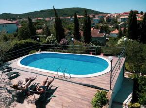 a swimming pool with two people laying in chairs next to a swimming pool at Franov Butique Residence in Kali