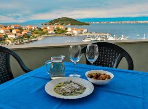 a blue table with two glasses and a bowl of food on it at Franov Butique Residence in Kali