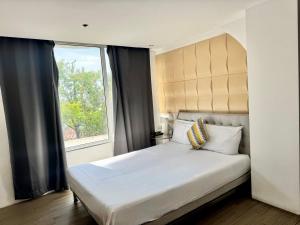 a bedroom with a large bed with a window at City Park Hotel Residences in Manila