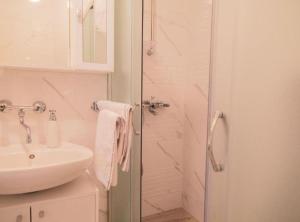 a white bathroom with a shower and a sink at Franov Butique Residence in Kali +30 photos