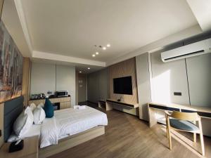 a bedroom with a white bed and a television at Fan's Hotel Palo in Tacloban
