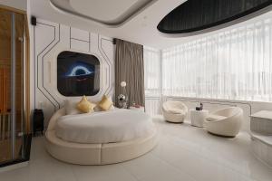 a bedroom with a bed and two chairs and a tv at Cupid Hotel 3 in Ho Chi Minh City