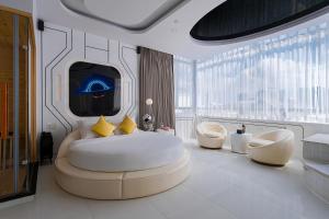 a bedroom with a bed and two chairs and a tv at Cupid Hotel 3 in Ho Chi Minh City