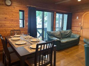 a dining room with a table and a couch at Kitakaze Chalet in Myoko