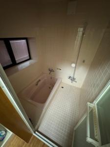 a bathroom with a bath tub and a window at Kitakaze Chalet in Myoko +16 photos