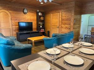 a dining room with a table and chairs and a television at Kitakaze Chalet in Myoko