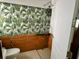 a bathroom with a toilet and a green and white wallpaper at Tiger on the Beach in Krabi +36 photos