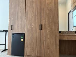 a black refrigerator in a kitchen with wooden cabinets at Tiger on the Beach in Krabi
